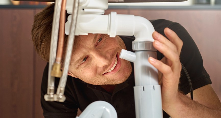 Bademiljø rørlegger skrur på plass nytt servantbatteri hos kunde