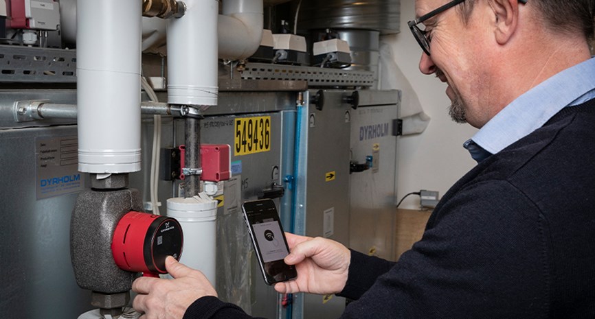 Rørlegger hjelper med montering av ny Grundfos sirkulasjonspumpe