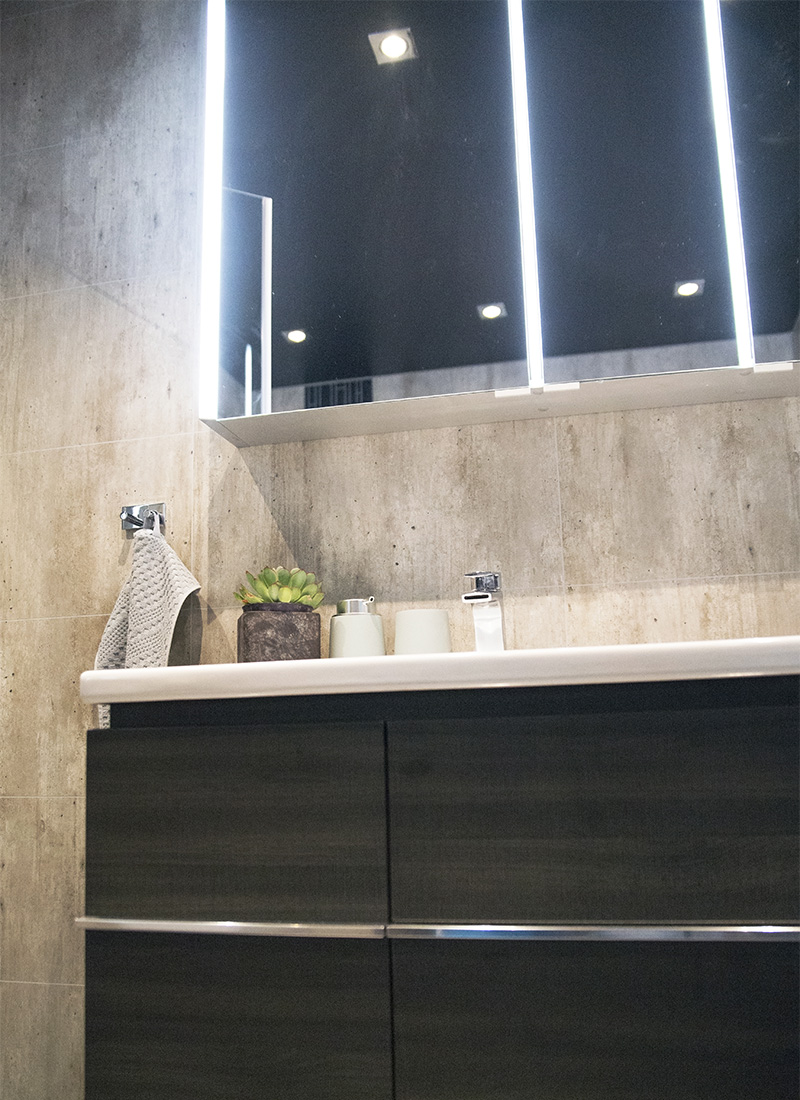 Mørkt drømmebad med innredning i mørk trestruktur