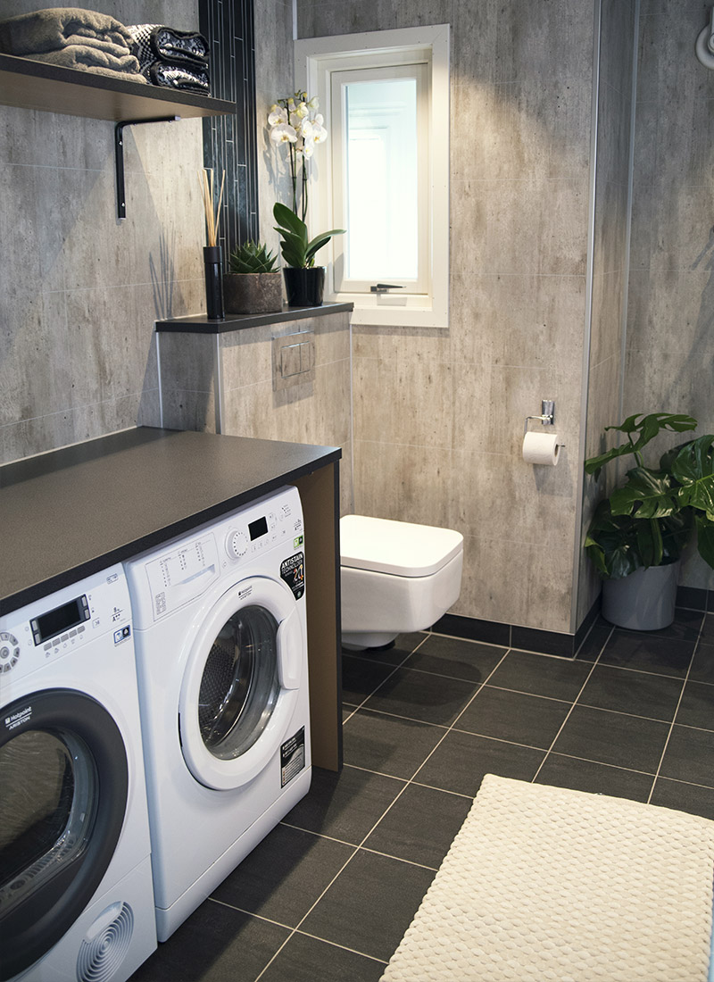 Mørkt drømmebad i kombinasjon med praktisk vaskerom